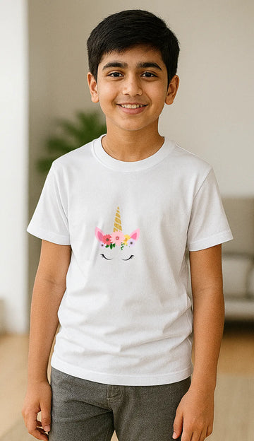 Young boy wearing a white t-shirt with a unicorn flower crown design, standing indoors.