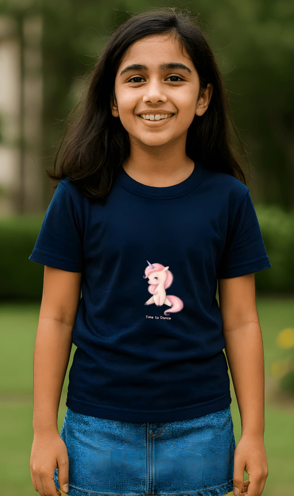 Young girl wearing a navy blue t-shirt with a pink pony graphic outdoors.