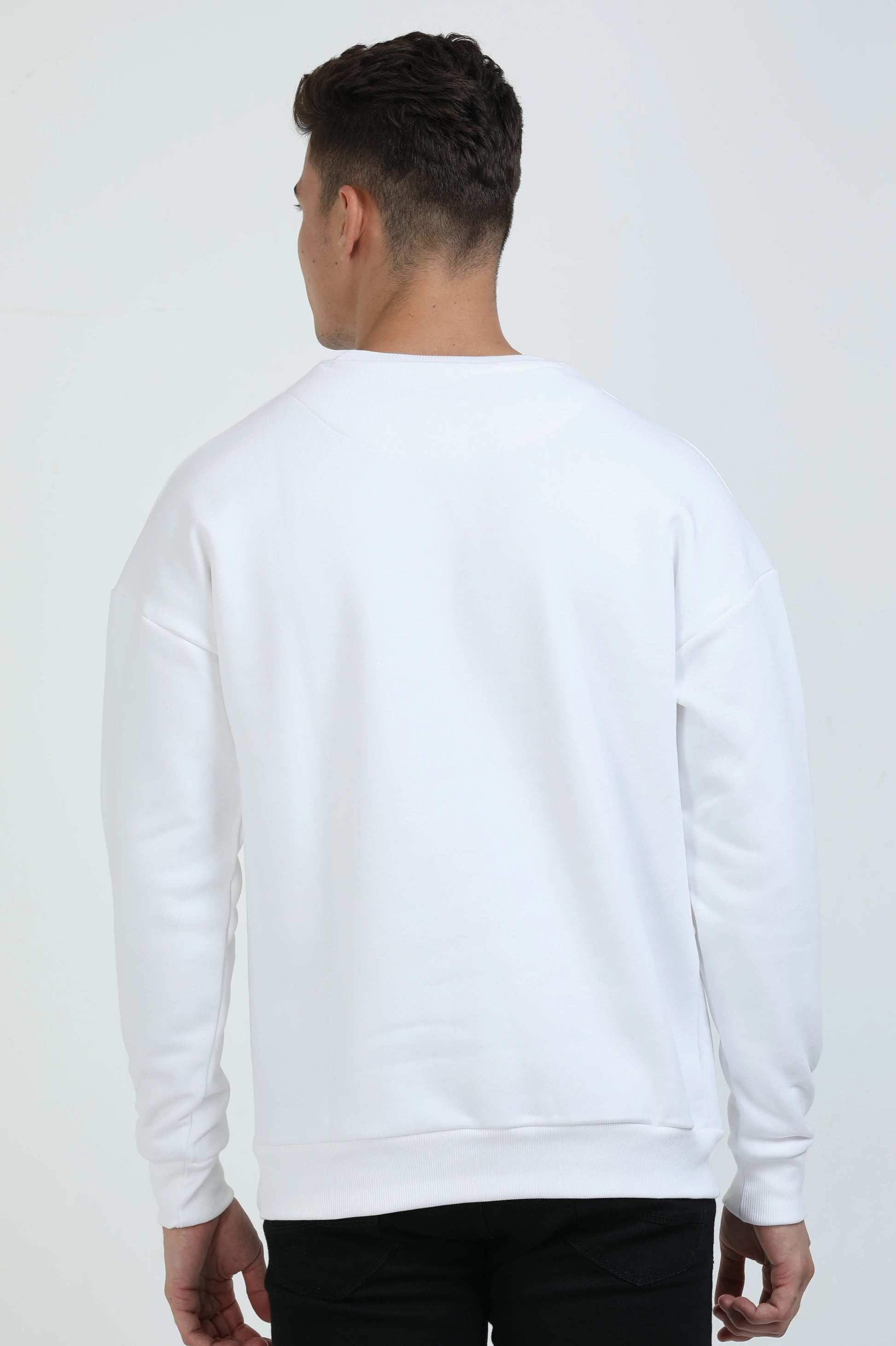 Person wearing a white sweatshirt on a plain background