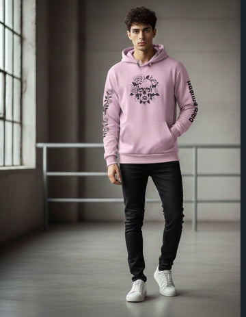 Person wearing a pink hoodie with a graphic design in a minimalistic indoor setting