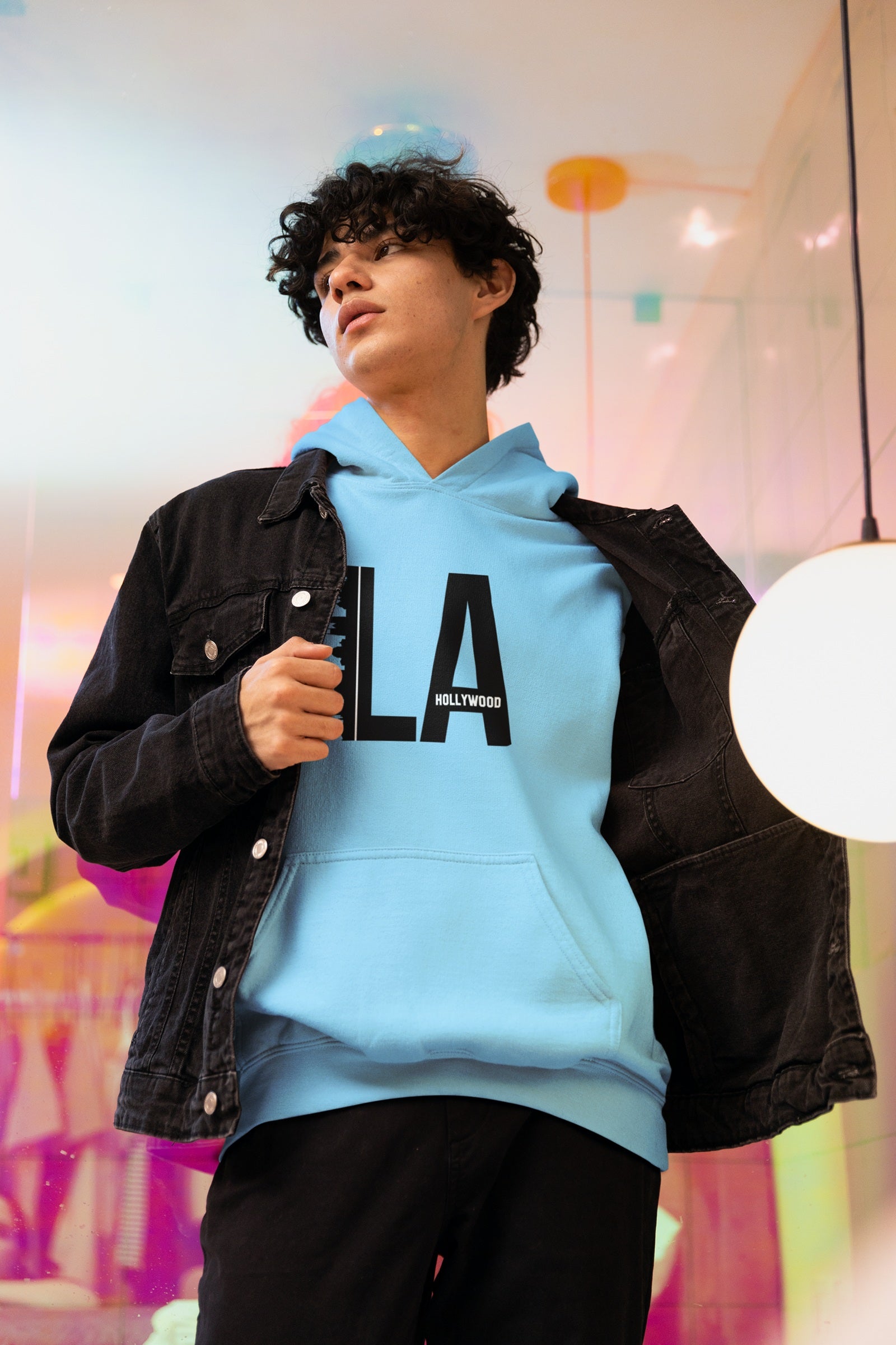 Model in Baby Blue 320 GSM Hoodie under jacket. Large LA Hollywood print, ideal for quality layering.
