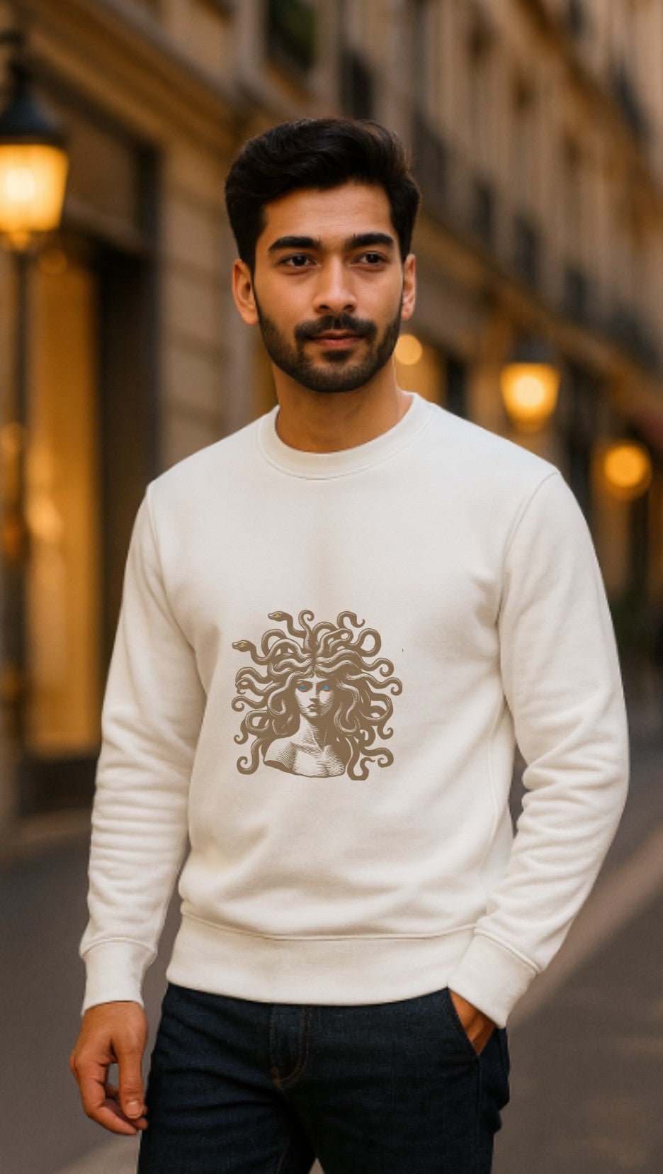 Man wearing a white sweatshirt with a Medusa with dark eyes design  in an urban setting