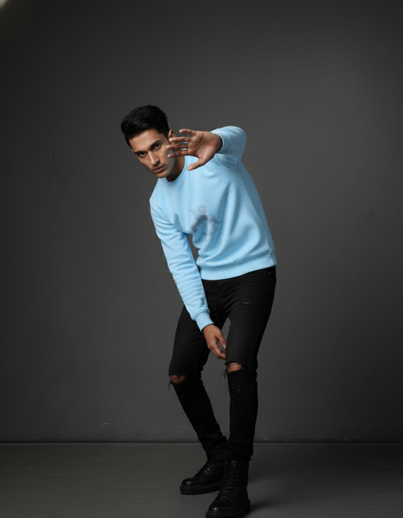 Man in Baby Blue 320 GSM Sweatshirt in pose with right hand raised, left hand on thigh. Unisex streetwear.
