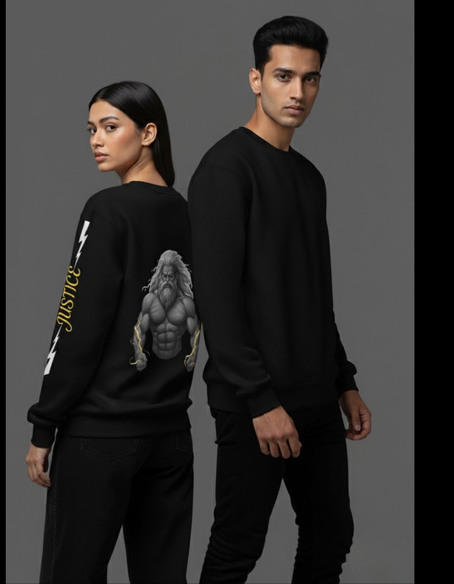 Two people wearing black sweatshirts with greek god on back and justice text in yellow with white lightning on two sides on sleeves.