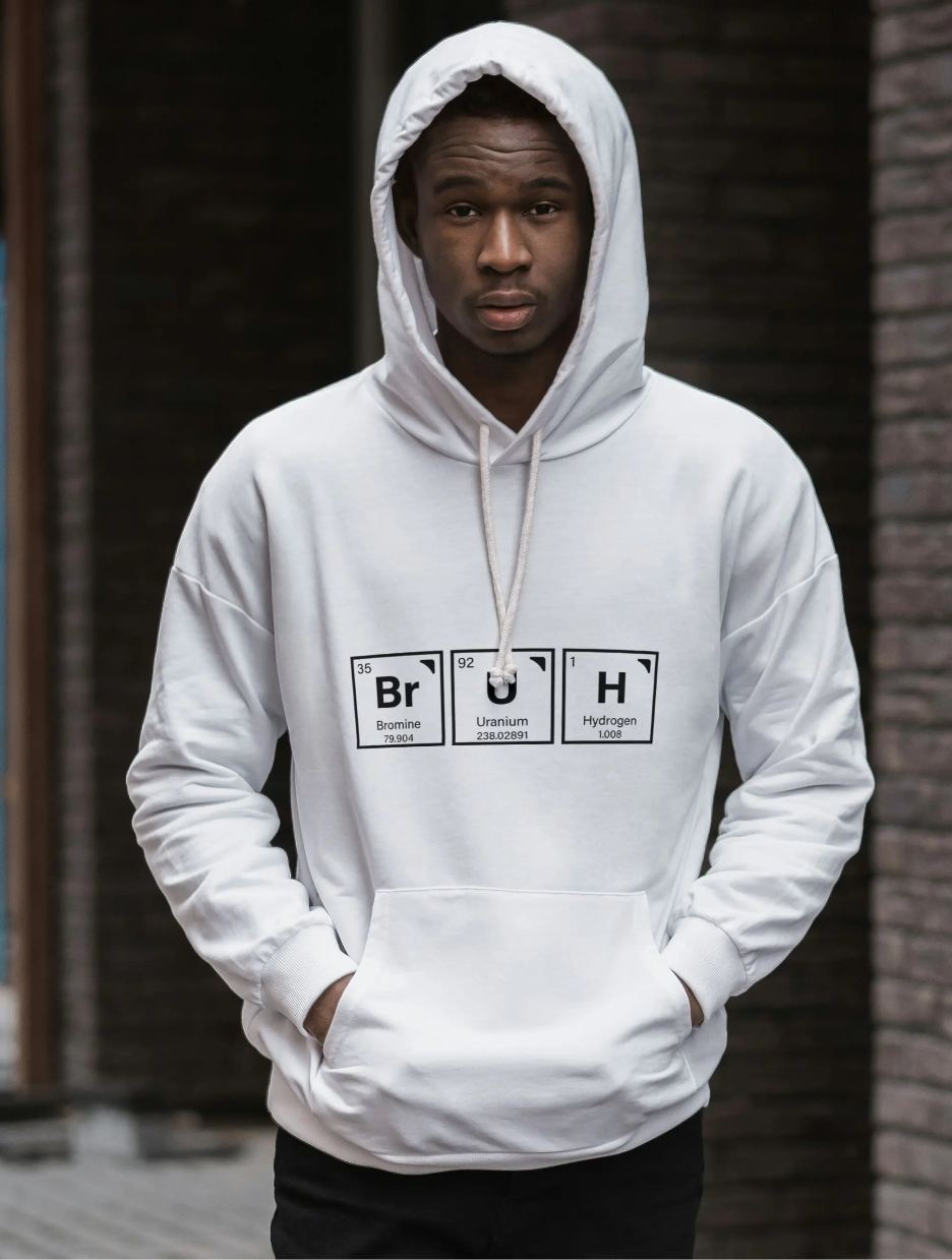 Person wearing a white hoodie with Casual text "Bruh" designed graphic standing left to a brick wall.